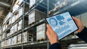 Professional monitoring IT infrastructure and assets in a warehouse environment using a digital tablet